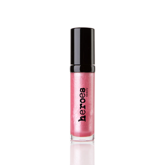 Image of a short clear tube with black lid.  It contains our Luxe Lip Gloss in a light shimmery pink colored lip gloss. 